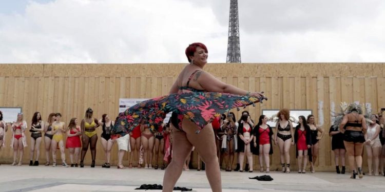 SIN IMPORTAR SU PESO, MUJERES POSAN CON FELICIDAD FRENTE A LA TORRE EIFFEL