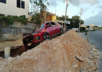 Conductora pierde el control de su camioneta y termina arriba de un montículo de tierra en Cancún