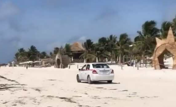 Captan a taxista circulando sobre la playa, en Tulum