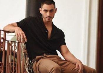 Alejandro Speitzer posa en croptop blanco y bolso azul al hombro aplicó lo de Bad Bunny