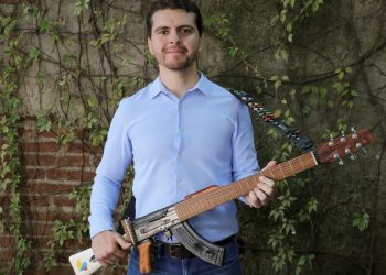 El Titular de Cultura en Culiacán causa polémica al posar con fusil AK-47 convertido en guitarra
