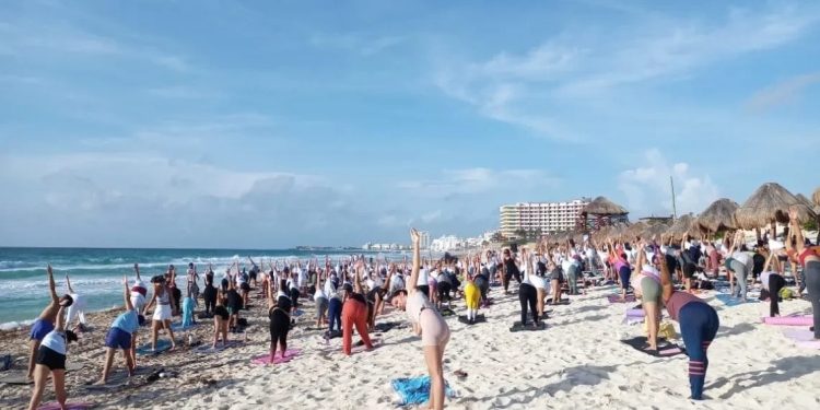 Cancunenses participan en el Día Internacional del Yoga en Playa Delfines